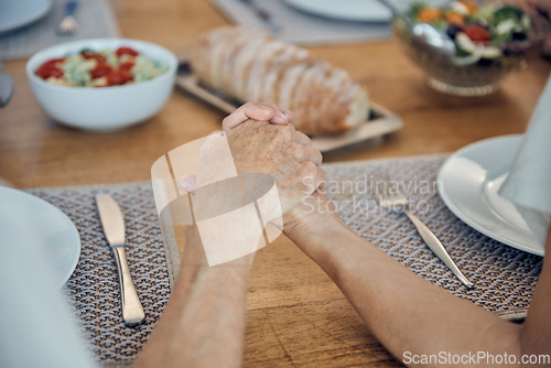Image of Family, food and prayer with senior couple holding hands, paying and gratitude at dining table for lunch, dinner and healthy diet. Man and woman saying grace, religion and grateful to pray and eat