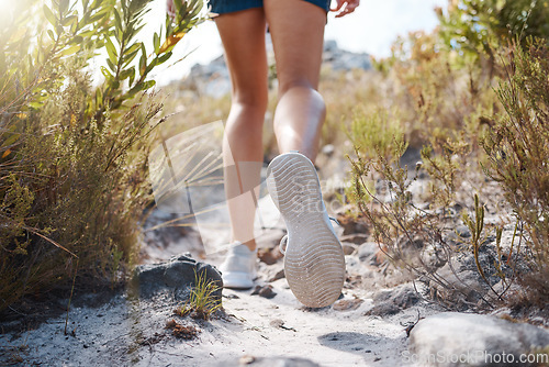 Image of Woman, legs and walking on mountains path in nature earth exploration, sustainability environment or Canada countryside hike. Zoom, hiker and hiking shoes on trekking trail in wellness health fitness
