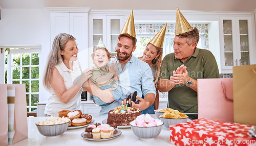 Image of Baby, birthday party and family celebration at a kid event with mother, father and friends. Young child and parents celebrate event with food clapping for a happy boy in a family home kitchen