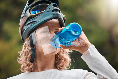 Image of Water bottle, drink and man in mountain bike travel, journey or adventure in nature forest for wellness, fitness or sports. Cycling sports person in safety helmet gear drinking water in the woods