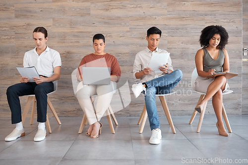 Image of Interview, waiting room and people with technology ready for interviewing and we are hiring team. Laptop, tablet and reading of office employee group looking at digital information to prepare for job