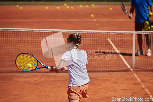 Image of A professional tennis player and her coach training on a sunny day at the tennis court. Training and preparation of a professional tennis player