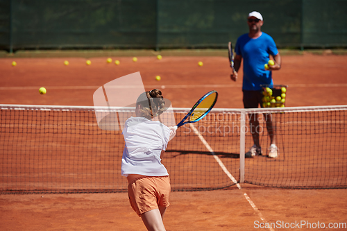 Image of A professional tennis player and her coach training on a sunny day at the tennis court. Training and preparation of a professional tennis player