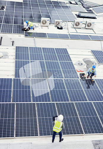 Image of Solar panel, construction and industrial employees on roof for solar energy, engineering and sustainable lifestyle. Building, sustainability and teamwork for clean electricity and photovoltaic power