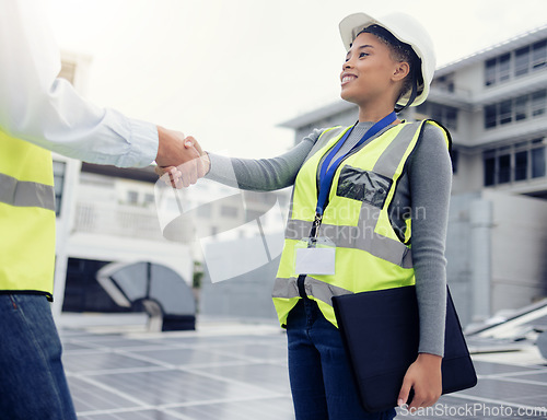 Image of Engineering team handshake, black woman at solar panel construction site or architecture project partnership. Working on building roof, industrial collaboration or contractor welcome employee