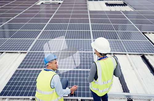 Image of Solar energy, construction and employees building solar panels in collaboration for sustainability, maintenance and engineering. Teamwork, planning and construction workers talking about clean energy