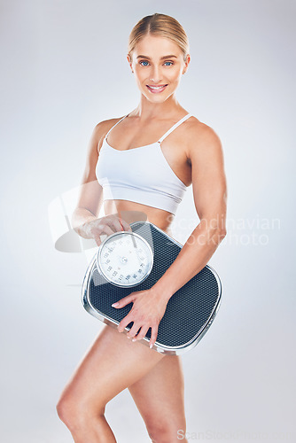 Image of Portrait, young woman and scale for weight loss, wellness and fitness with studio background. Health nutrition, healthy female or trainer happy, for results after weighing and body care for wellness