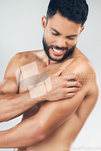 Image of Beauty, body and injury with a man model holding his shoulder in pain in studio on a gray background. Fitness, health and anatomy with a young male suffering with muscle cramp, ache or inflammation