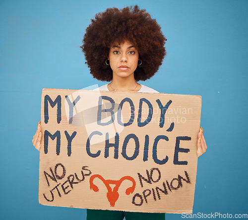 Image of Protest, human rights and woman with a poster for abortion, body freedom and justice against a blue studio background. Choice, equality and portrait of an African girl with a board for a riot