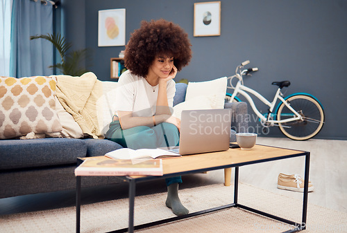 Image of Laptop, education and learning with a black woman student watching an online video while studying in a living room. Computer, study and homework with a female university or college pupil in her home