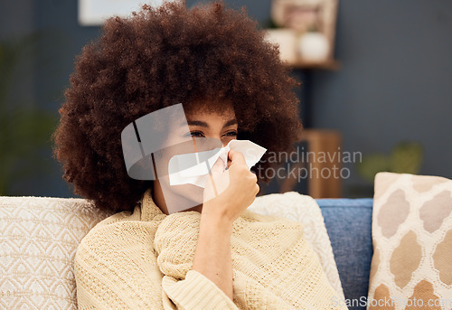 Image of Sick, sad and woman with covid blowing nose on the sofa with a blanket in the lounge of a house. Burnout, virus and African girl with a tissue to wipe nose with flu, cold or medical problem in home