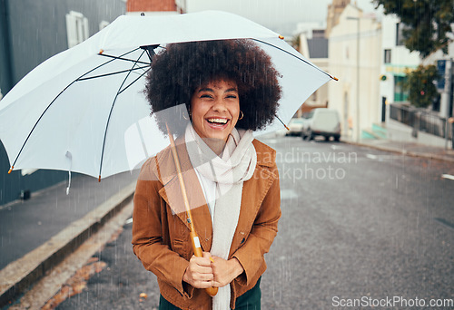 Image of Rain, umbrella and city with a walking black woman in the street during a cold or wet winter day. Water, insurance and cover with a young afro female outdoor for a walk in an urban town road