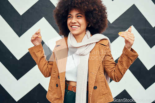 Image of Black woman afro, smile and trendy fashion on urban background and happy haircare or creative beauty. Woman, happiness and curly african hair, art wall city or metro hand sign in New York for style