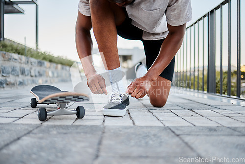 Image of Black man, shoes and skateboard, skater with shoelace in urban skate park for fitness, exercise and fun outdoor. Young person, cool and trendy out in nature, skating with sneakers and cityscape.