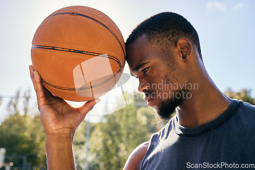 Image of Basketball on forehead, motivation and black man on basketball court ready for competition, match or game. Basketball player, sports and male from Nigeria preparing for training, fitness or exercise.