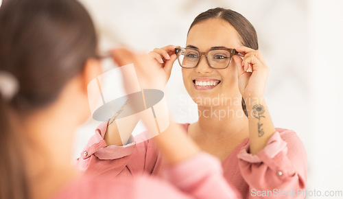 Image of Vision, mirror and happy woman trying on glasses to choose a new frame at an optometry store. Smile, eyewear and lady choosing spectacles with a prescription lens after an eye exam at optical clinic,