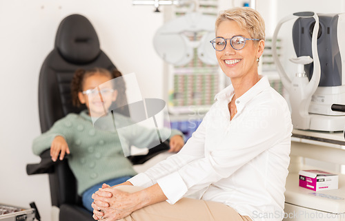 Image of Ophthalmologist, child patient and vision test or eye exam for eye care to check and examine eyesight at a clinic or optometry store. Portrait of woman doctor or specialist ready for optics care