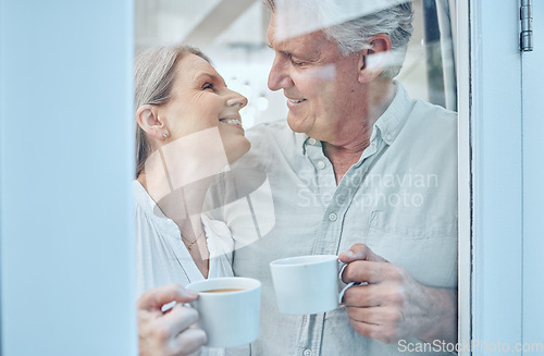 Image of Retirement, coffee and love with a senior couple drinking or enjoying a beverage together in their home. Relax, romance and bonding with an elderly man and woman pensioner by a door in their house