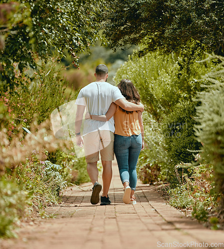 Image of Hug, walk and couple on a path in nature for peace, relax and bonding together in summer. Back of a man and woman with affection, hugging and walking with love in a park or garden during spring