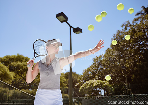 Image of Tennis, tennis ball and woman serving for fitness training, cardio workout and sports exercise outdoors in summer. Focus, action and healthy athlete serves multiple balls on a tennis court in a game