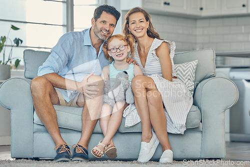 Image of Happy, smile and portrait of a family on a sofa to relax and bond together in the living room of their home. Happiness, mother and father sitting with their girl child on couch in their modern house.