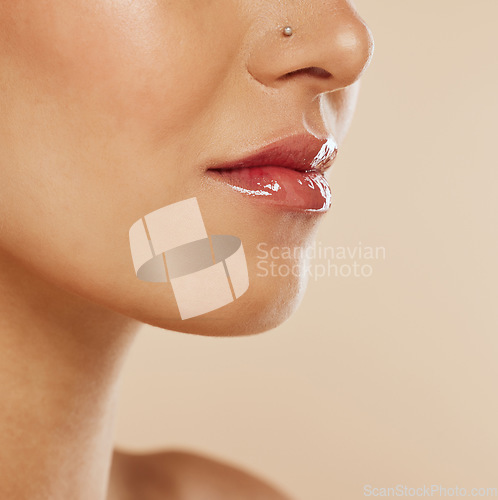 Image of Beauty, lips and mouth with lip gloss, lipstick and cosmetics makeup product for mockup skincare advertising on beige studio background. Dermatology, cosmetology and self care wellness of model skin