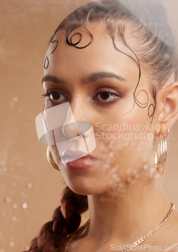 Image of Face, beauty and skincare with a model woman in studio with jewelry, cosmetics and jewelry for fashion and natural makeup behind droplets glass. Gen z, aesthetic female and skin glow for dermatology