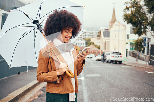 Image of Black woman, winter on city street and smartphone in hand browsing social media, online conversation and umbrella in hand waiting for taxi in rain. Mobile GPS technology, happy smile and cell message