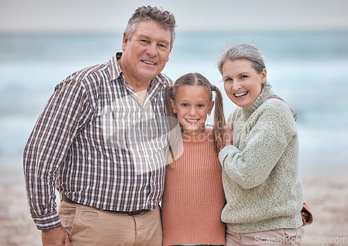 Image of Happy family, portrait and girl at the beach with grandparents relax, bond and smile, hug and love. Happy, seniors and child enjoy family time in nature, seaside and ocean fun on vacation together