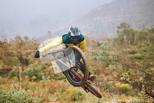Image of Mountain bike, man and air jump, action and bicycle stunt, challenge and adventure, freedom or dynamic risk in outdoor competition race. Biker athlete, sports adrenaline and energy for extreme sports