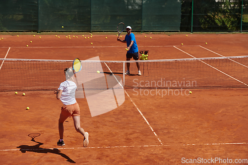 Image of A professional tennis player and her coach training on a sunny day at the tennis court. Training and preparation of a professional tennis player