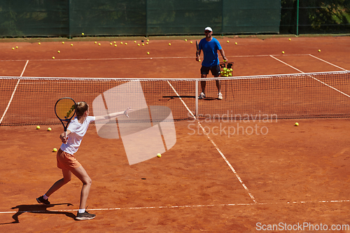 Image of A professional tennis player and her coach training on a sunny day at the tennis court. Training and preparation of a professional tennis player