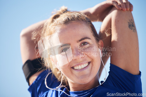 Image of Fitness, portrait and woman stretching in a city before workout with music for health, wellness and running against a blue sky. Sports, stretch and face of happy athlete listening to radio or podcast