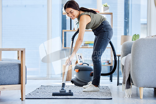 Image of Smile, vacuum machine and woman cleaning the floor in the living room in home. Happy latino cleaner doing housework, housekeeper or job in a clean lounge, hotel room or house while spring cleaning