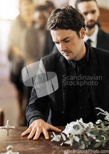 Image of Sad, funeral and coffin with man in church for death, mourning and respect at burial ceremony. Flowers, depression and grief with family goodbye at casket in chapel for loss, remember and sorrow