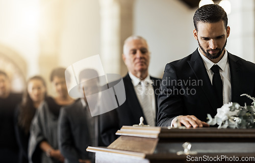 Image of People, sad and funeral coffin, death and grief in church during ceremony or service, depression or floral. Support, emotional pain and sorry with casket, mourning and man in suit at casket in chapel