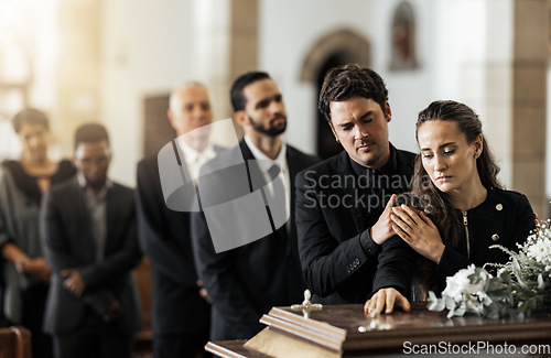 Image of Death, funeral and family touching coffin in a church, sad and unhappy while gathering to say farewell. Church service casket and sad man and woman looking upset while greeting, goodbye and rip