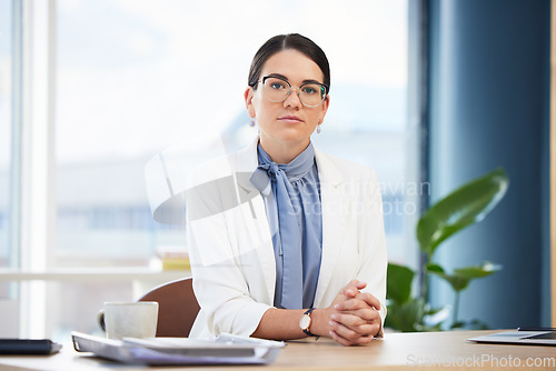 Image of Portrait of doctor working in her office at hospital with healthcare, medicine or medical paperwork. Serious, woman and professional surgeon sitting at a desk doing research on health care at clinic.