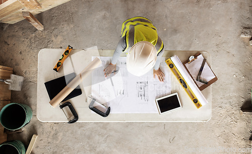 Image of Engineering, building and aerial of construction worker with blueprint, tools and digital tablet on desk. Architect check engineering design, floorplan and drawing at workstation in construction site