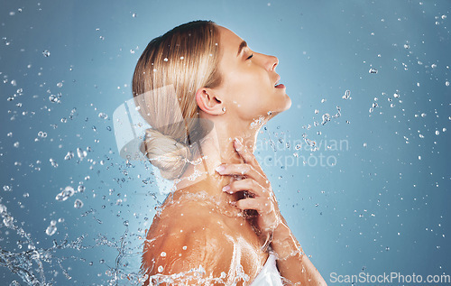 Image of Skincare, water and profile of woman on blue background in studio for beauty, facial and wellness. Hydration, skincare products and girl model for washing, cleaning and body cleanse at luxury spa