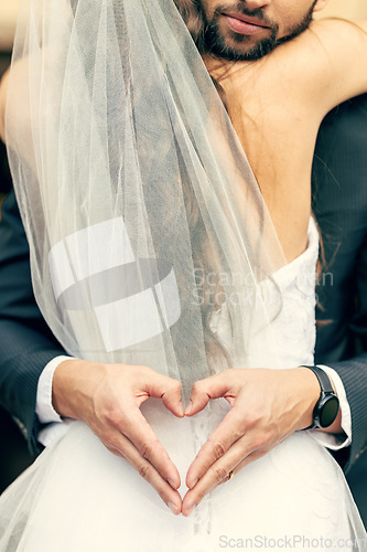 Image of Hand, heart and bride and groom hug at their wedding, happy and relax while sharing an intimate moment. Hands, love and couple celebrate their marriage, embrace and having fun while showing emoji