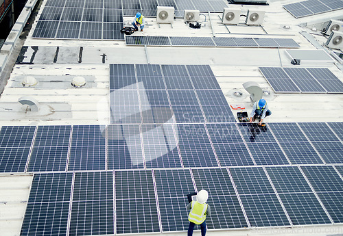 Image of Grid, solar energy and roof construction engineering people working on renewable energy installation. Sustainability, solar panel and professional contractor team work on building rooftop.
