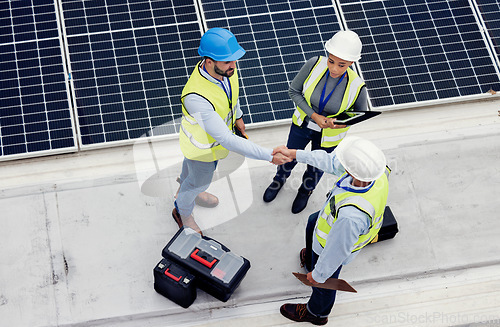 Image of Handshake, engineering and team working on solar panels for inspection, maintenance or installation. Eco, solar energy and industrial workers shaking hands for a industry deal, agreement or teamwork.