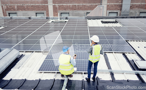 Image of Engineer, planning and solar panel installation, maintenance and teamwork for renewable energy on a roof outdoor. Collaboration, planning and construction workers talking about clean or solar energy