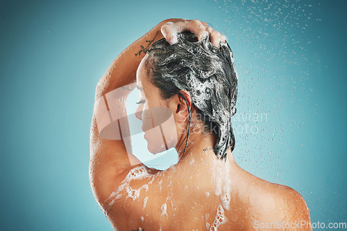 Image of Beauty, shower and woman cleaning, haircare and shampoo while washing against a blue studio mock up background. Back, model and clean in bathroom for skincare, health and wellness with water and soap