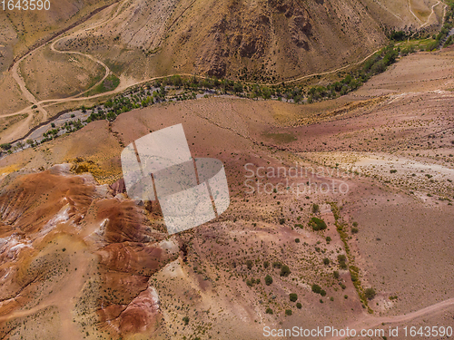 Image of Aerial shot of the textured yellow nad red mountains resembling the surface of Mars