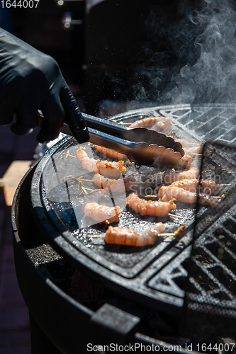 Image of A professional cook prepares shrimps