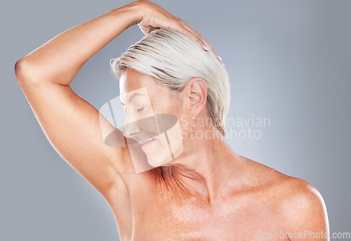 Image of Beauty, skincare and anti aging with a senior woman in studio on a gray background to smell her armpit. Wellness, health and cosmetics with a mature female posing to promote a fresh skin product