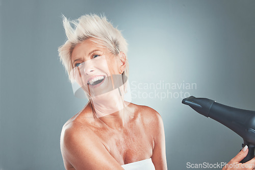 Image of Hair, hairdryer and senior woman in studio for beauty, stylish and hair care on grey background mockup. Grey hair, mature woman and elderly woman wellness model dry hair, happy, relax and having fun