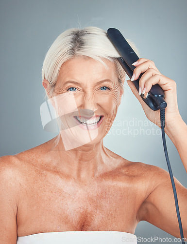 Image of Portrait of an old woman in studio with a hair iron for grooming, hair care treatment and salon hairstyle. Beauty, self care and happy elderly person hairdressing with a hair straightener for shine